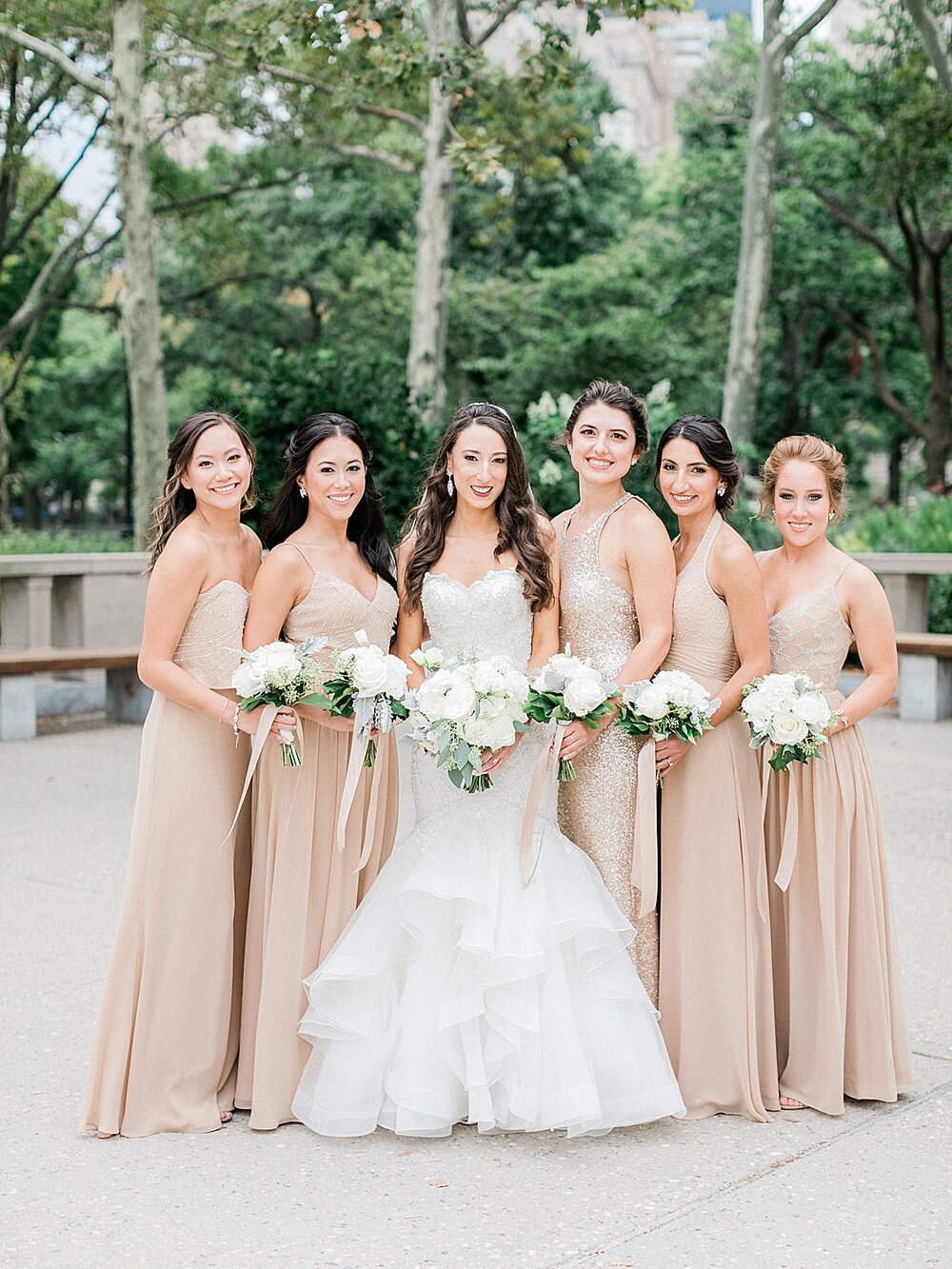 bride poses with bridesmaids in champagne gowns in Battery Park | Tri-State area wedding venues photographed by Asher Gardner Photography