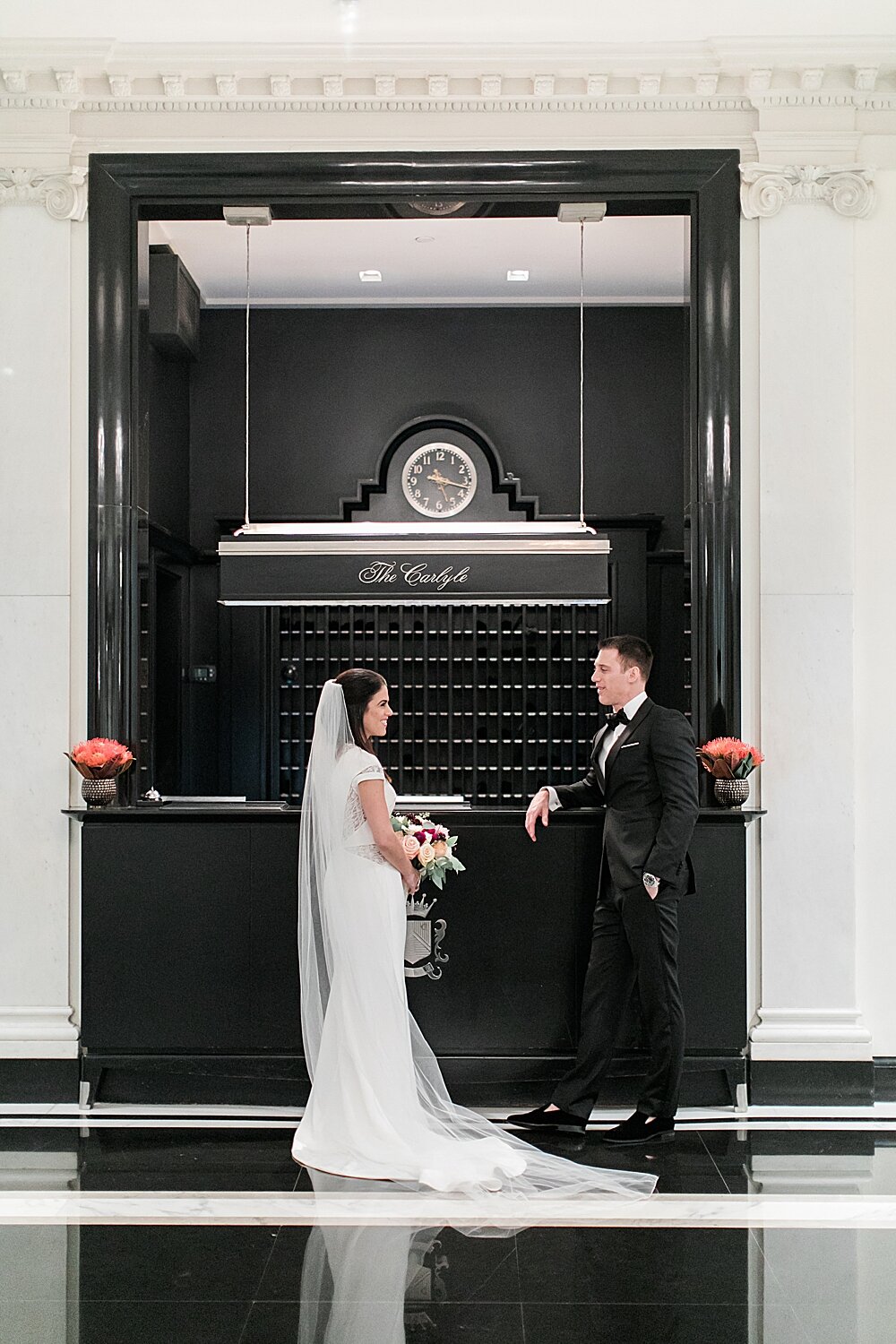 bride and groom pose by check in desk at The Carlyle | Tri-State area wedding venues photographed by Asher Gardner Photography