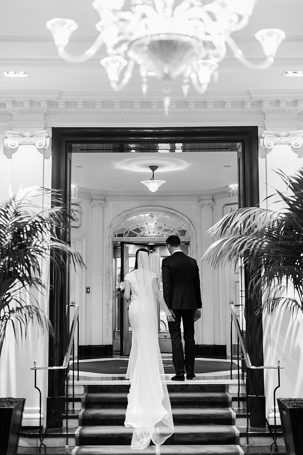 bride and groom walk up steps in historic Carlyle Hotel | Tri-State area wedding venues photographed by Asher Gardner Photography