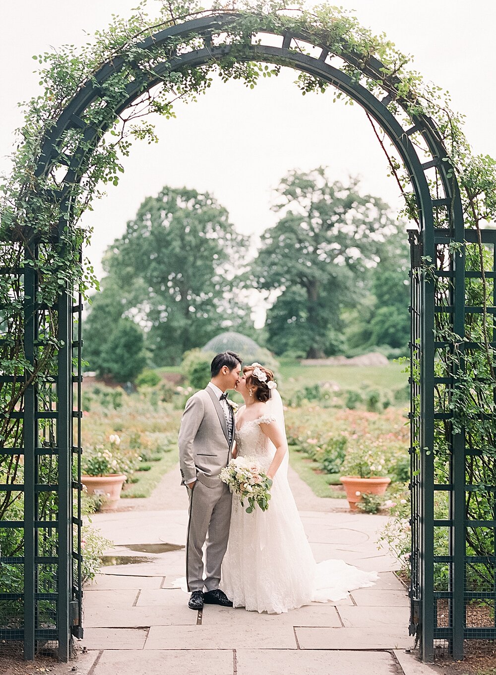 bride and groom pose under arbor in New York | Tri-State area wedding venues photographed by Asher Gardner Photography