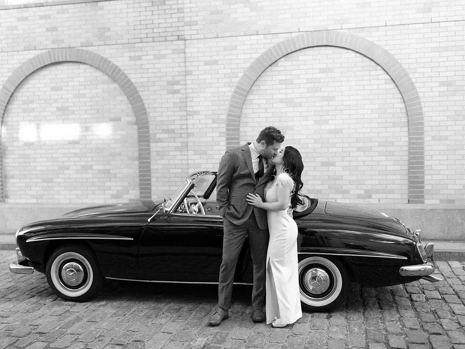 engaged couple hugs in front of classic Mercedes Benz in Hoboken NJ