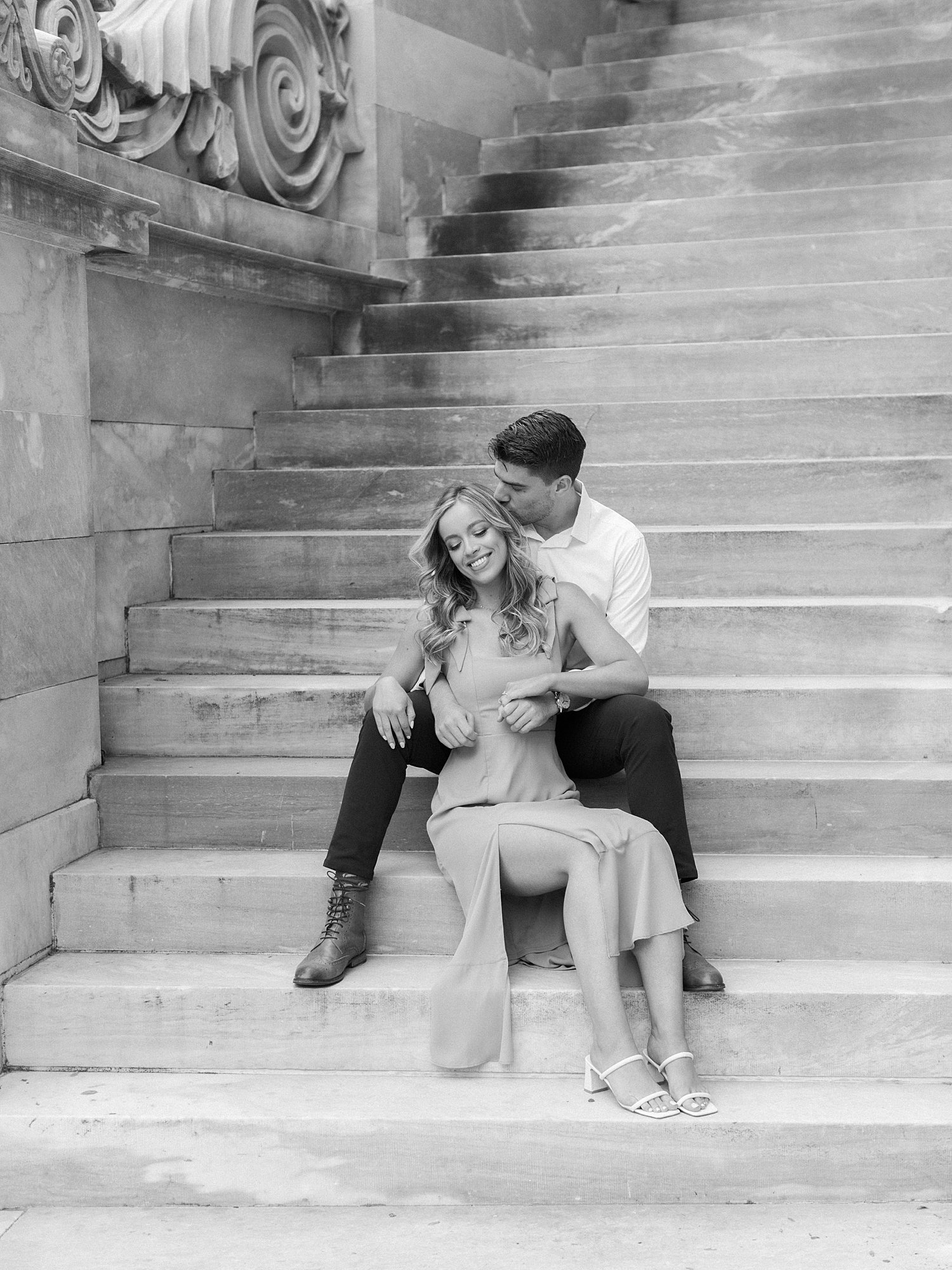 couple sits together on steps of the Merchant Exchange Building