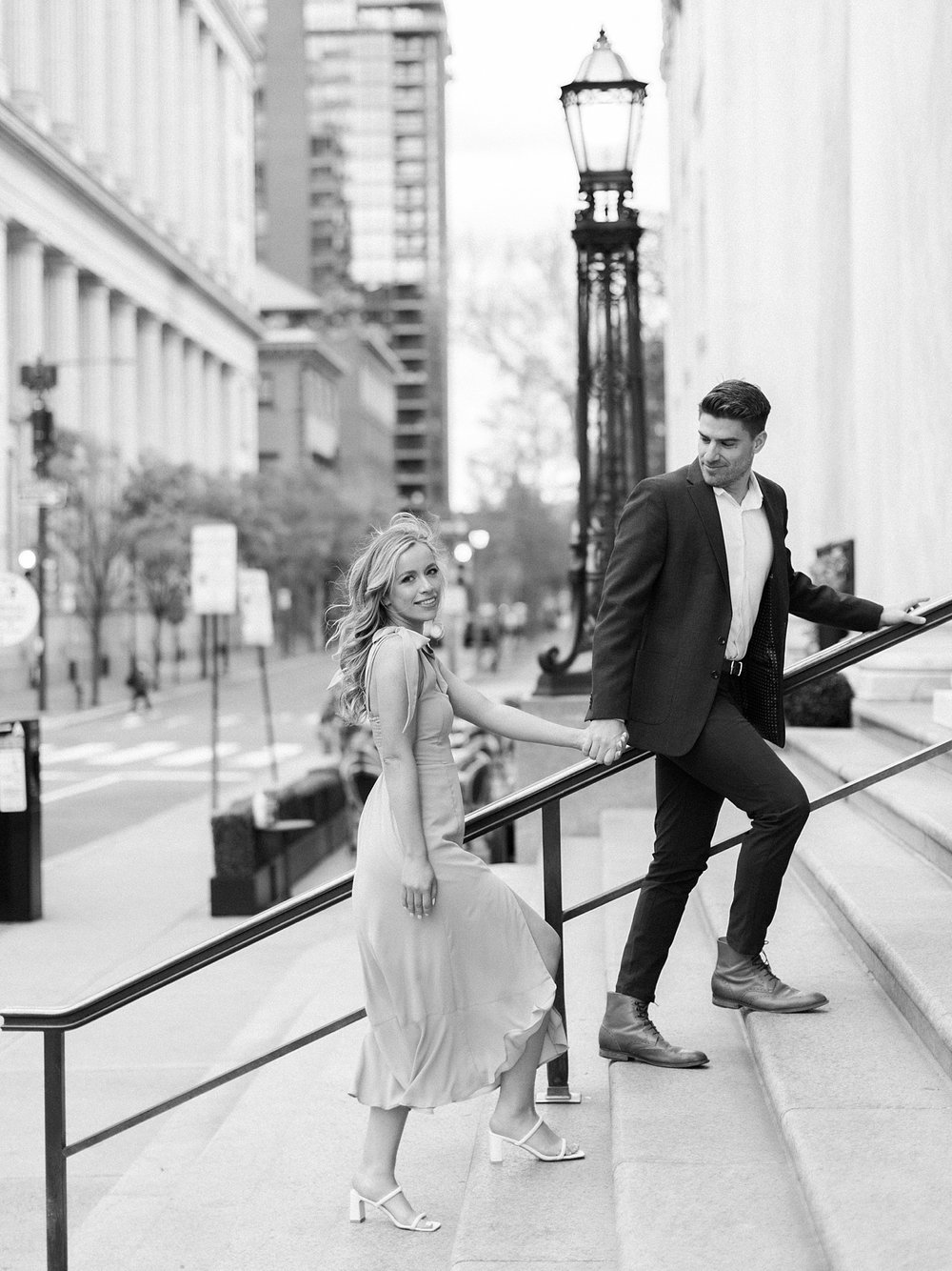 engaged couple walks up steps of Philadelphia City Hall