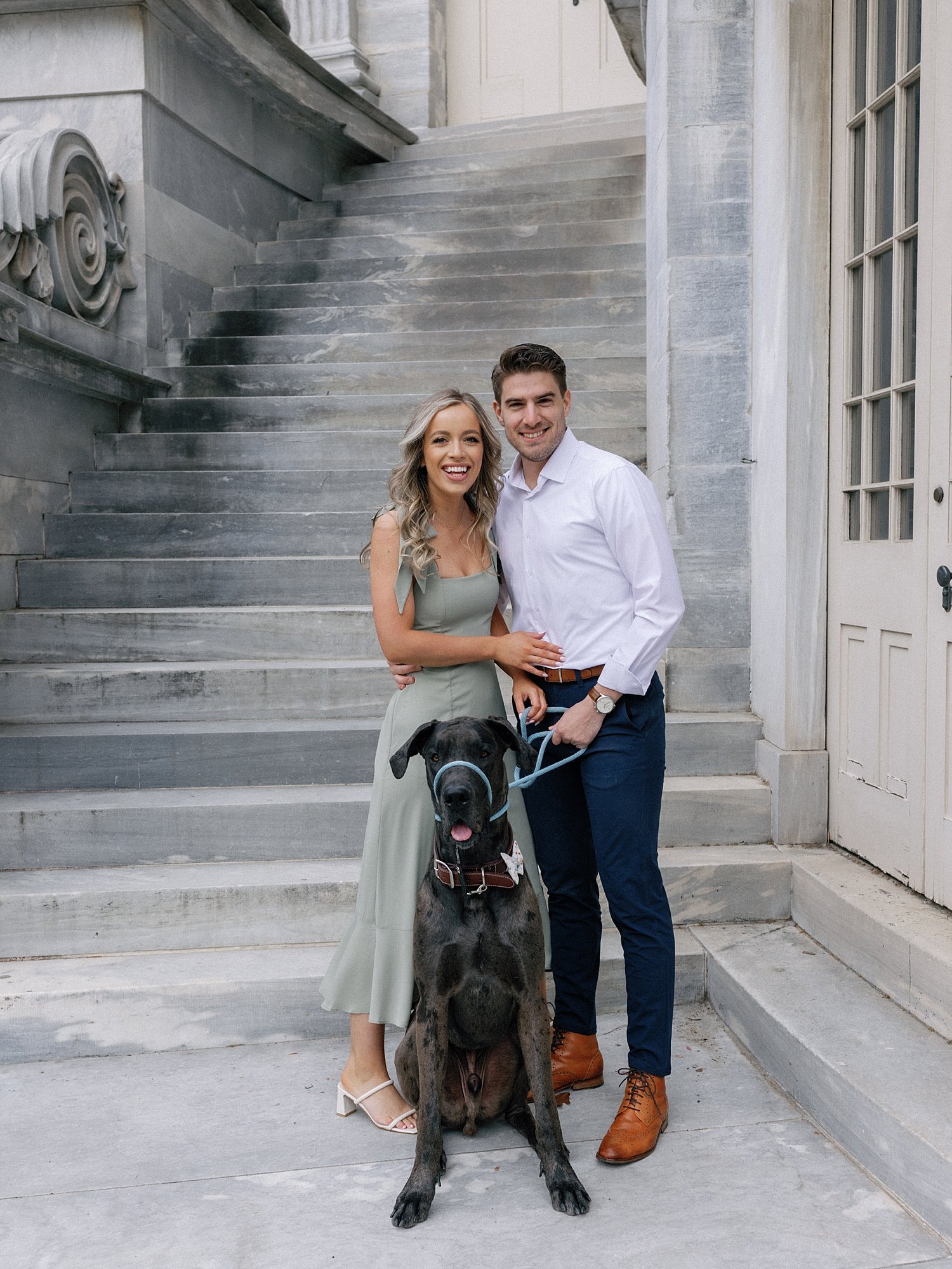 engaged couple stands in front of the Merchant Exchange Building with Great Dane