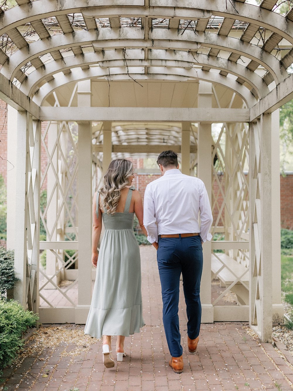 bride and groom hold hands walking through gazebo in Philly PA