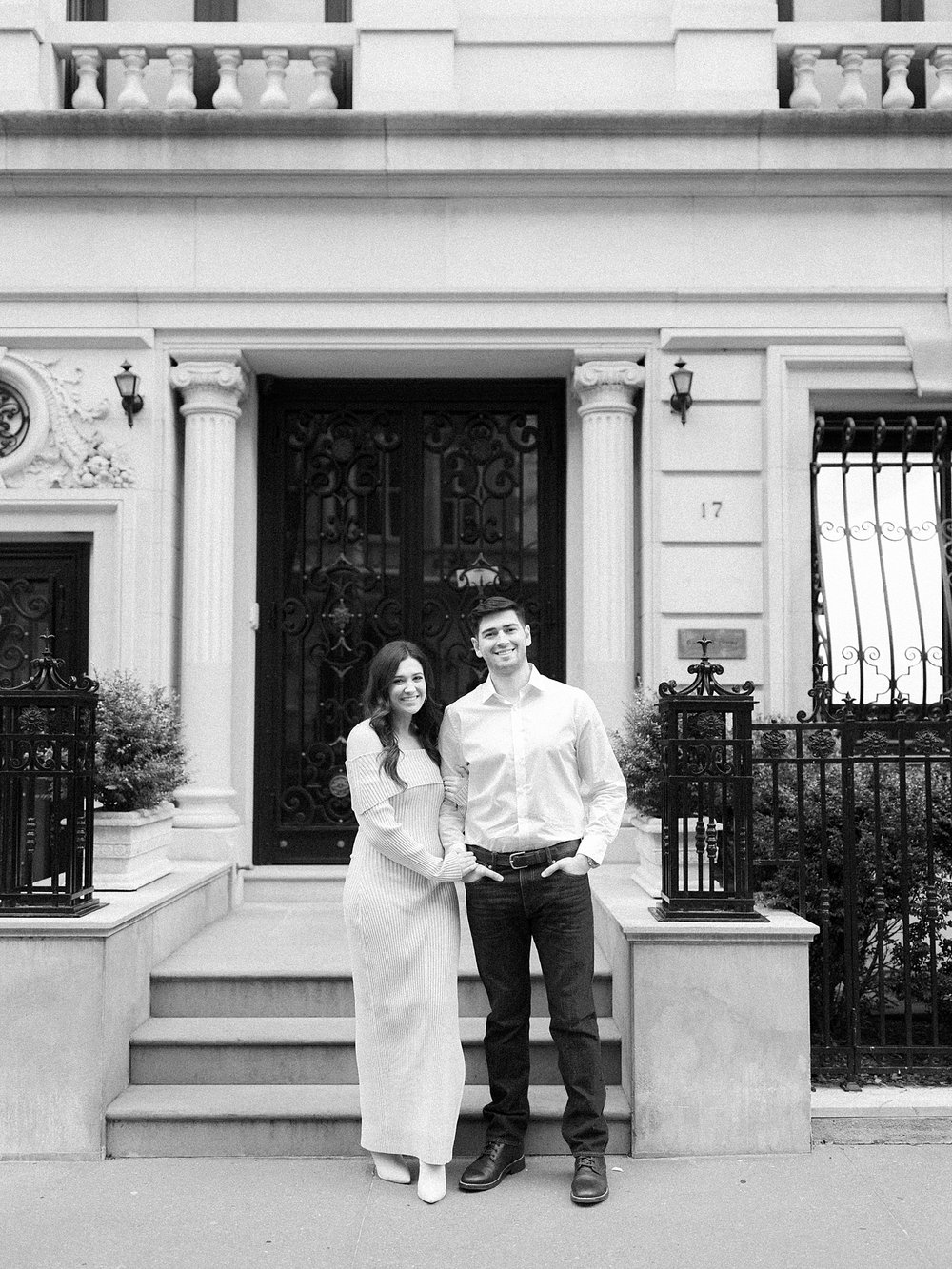 engaged couple stands in front of stoop on the Upper East Side in NYC