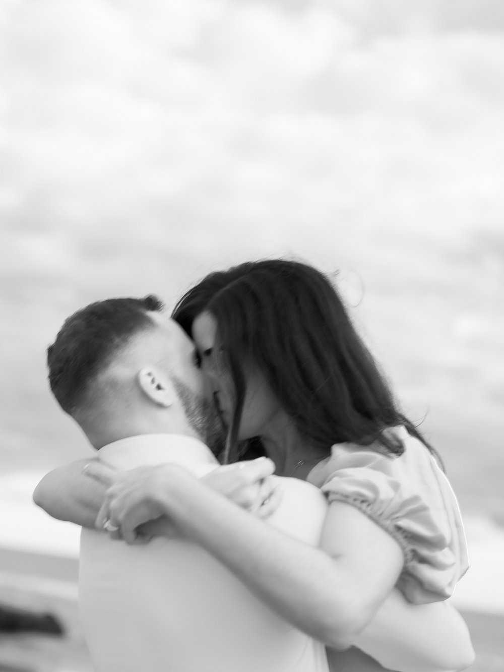 engaged couple kisses on overcast day in Ocean City NJ