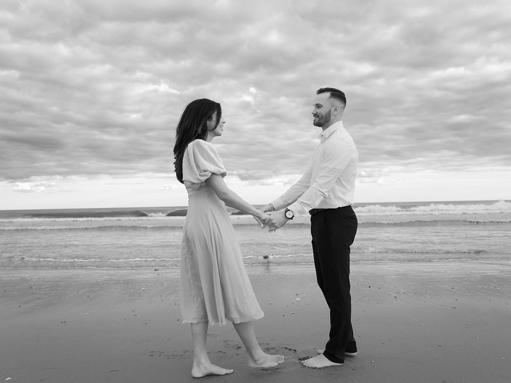 engaged couple holds hands under stormy sky in Ocean City NJ