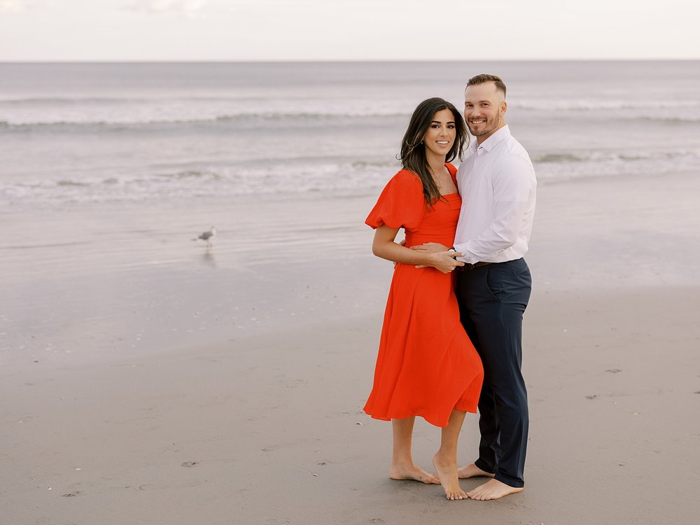 engaged couple hugs standing together on beach in Ocean City NJ