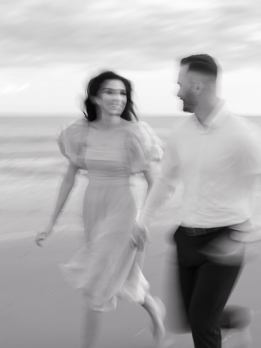 blurry photo of couple running down beach in New Jersey