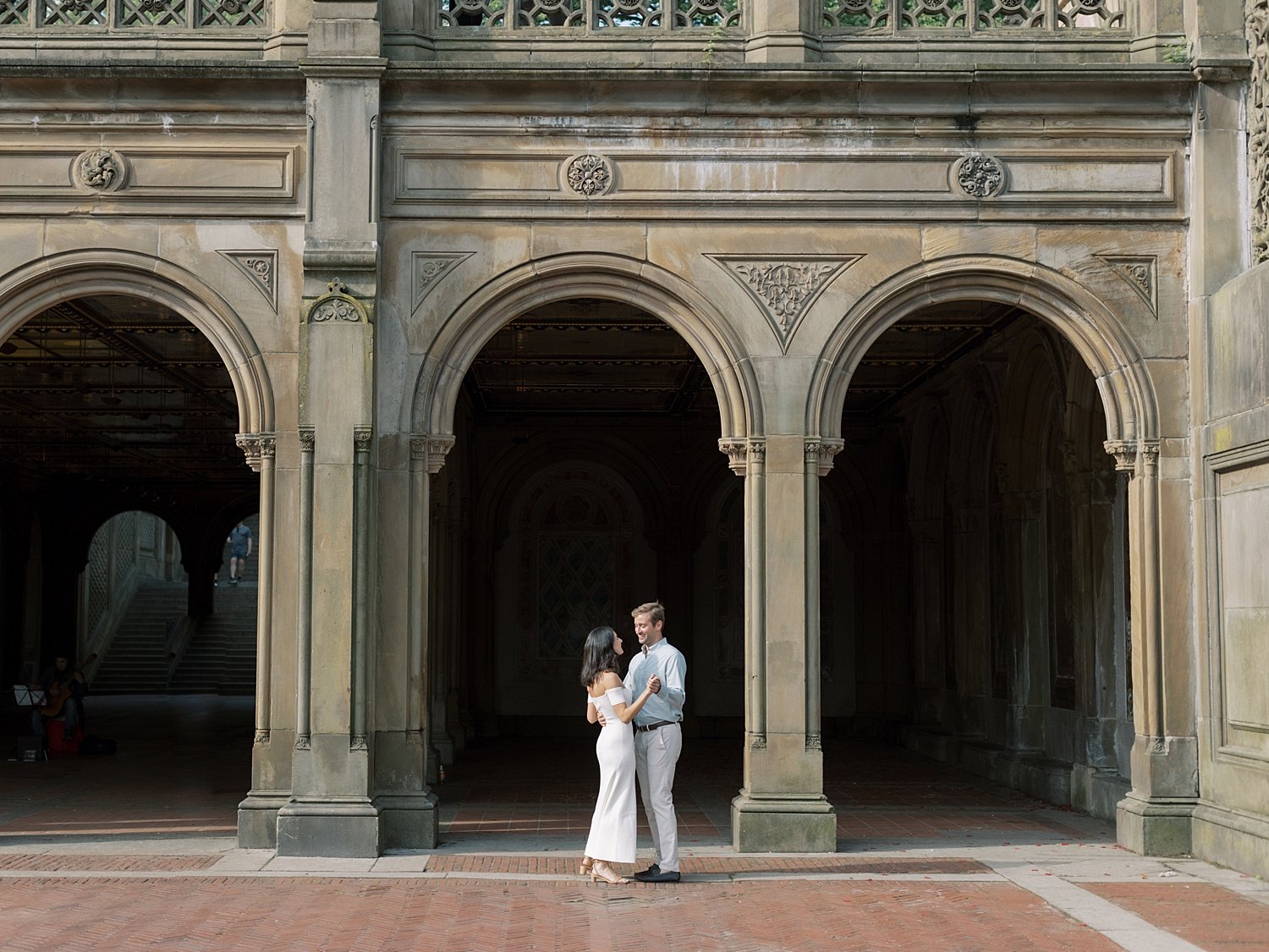 man and woman hug under arch inside Central Park