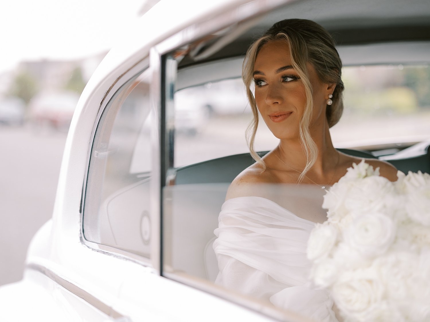 bride smiles out the window of white vintage car in New Jersey
