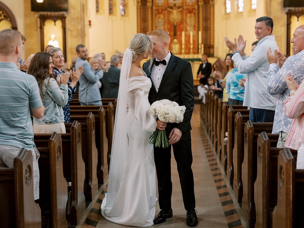 newlyweds kiss in aisle after traditional church wedding on Long Island