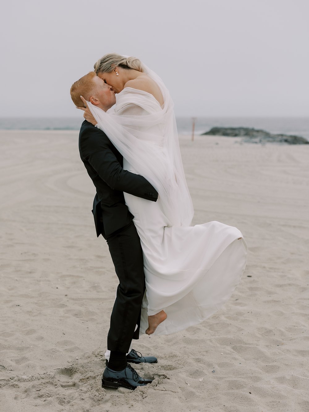 bride and groom kiss on Long Island beach