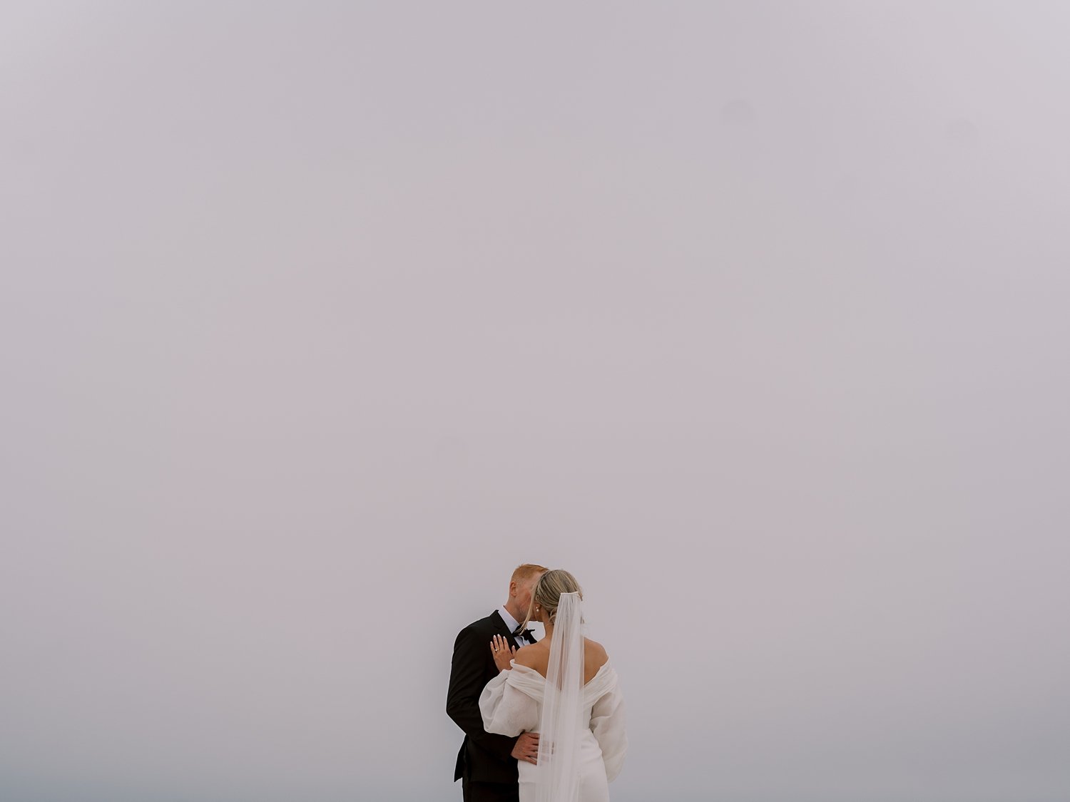 bride and groom kiss during sunset on Long Island beach