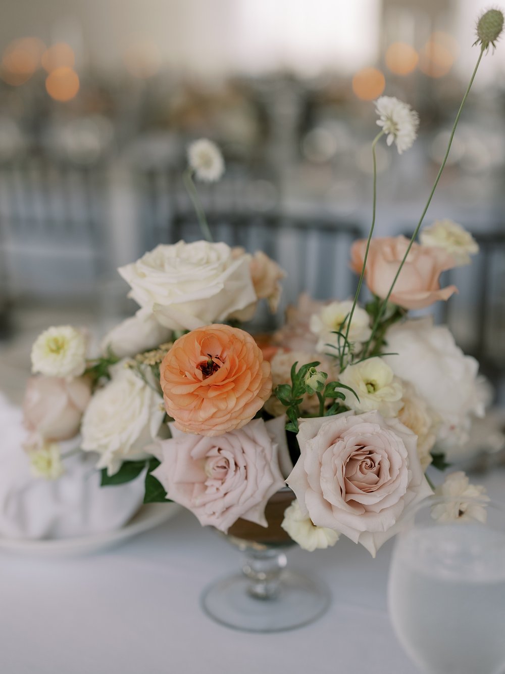 centerpieces with ivory, peach, and pink flowers