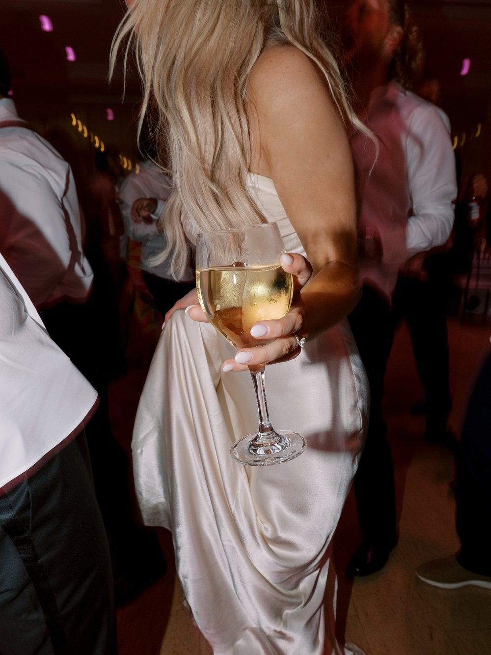 bride dances holding glass of wine