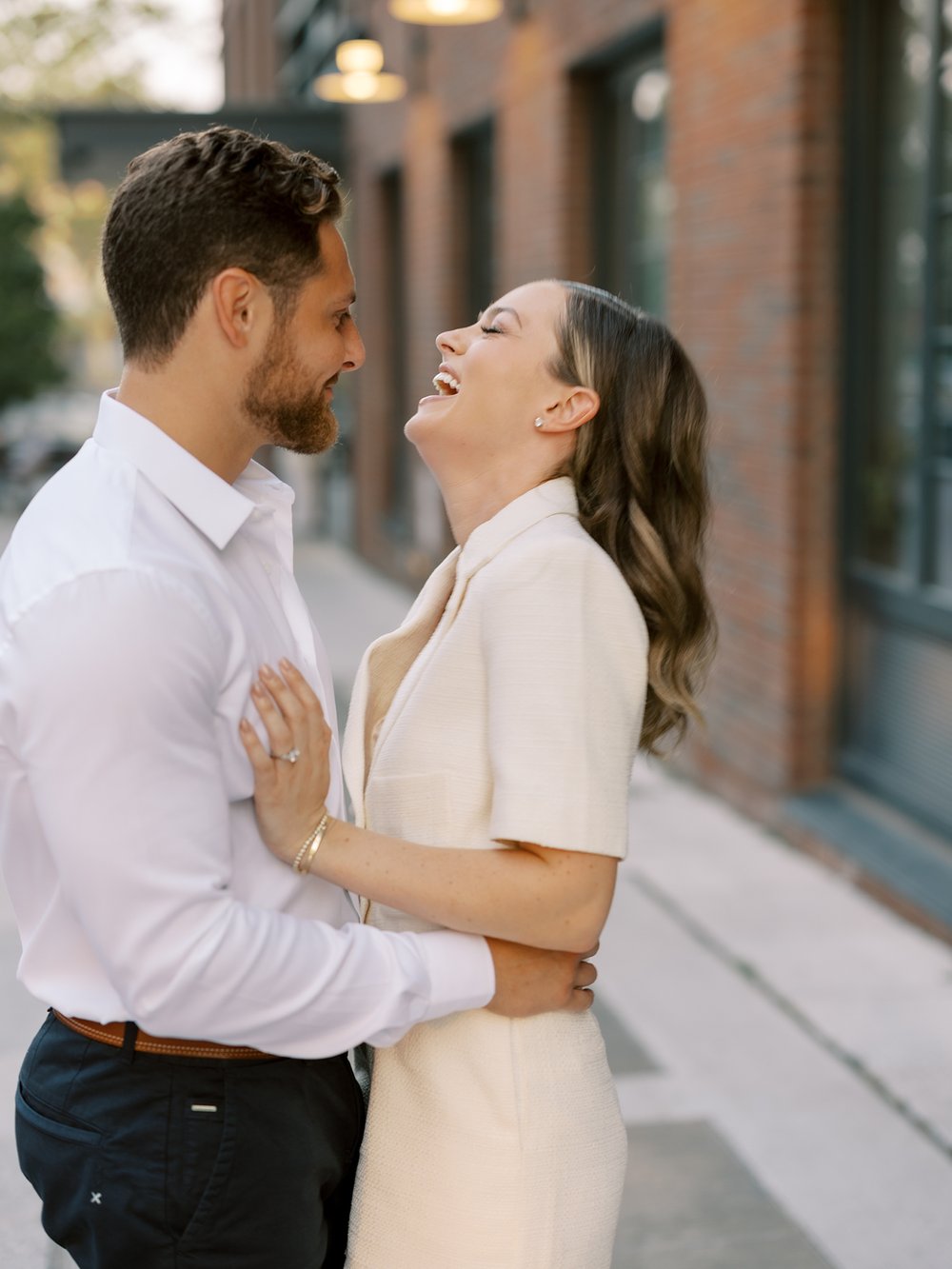 man hugs fiancee making her laugh during Brooklyn engagement session 