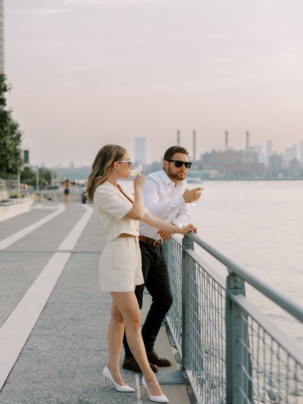 couple drinks champagne looking at sunset from Greenpoint Waterfront Park