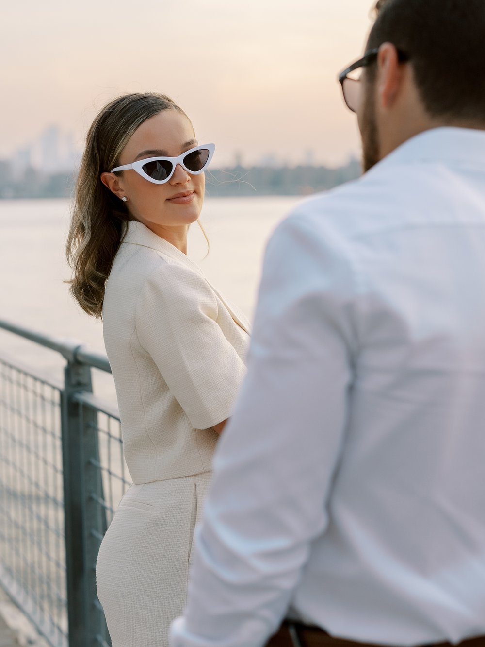 man looks at woman looking over her shoulder in white retro sunglasses 