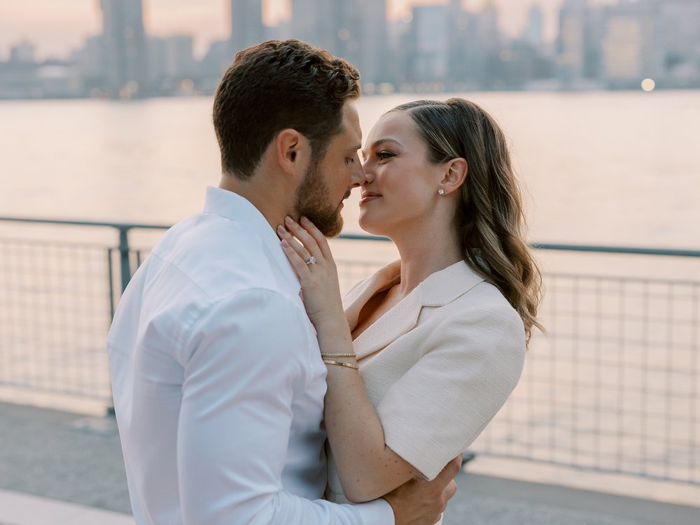 engaged couple kisses at sunset in Greenpoint Waterfront Park