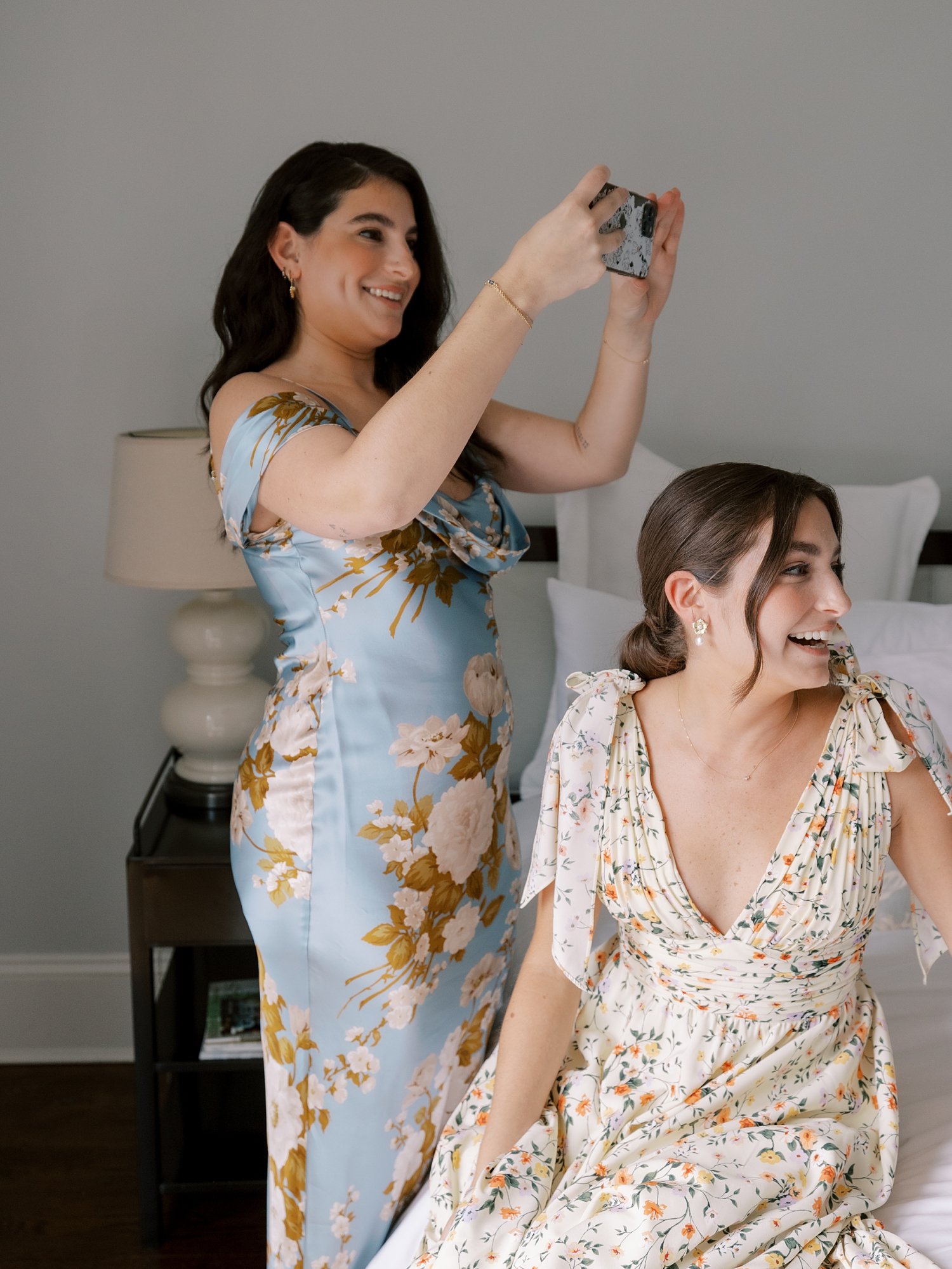 bridesmaid holds up phone to take photo of bride