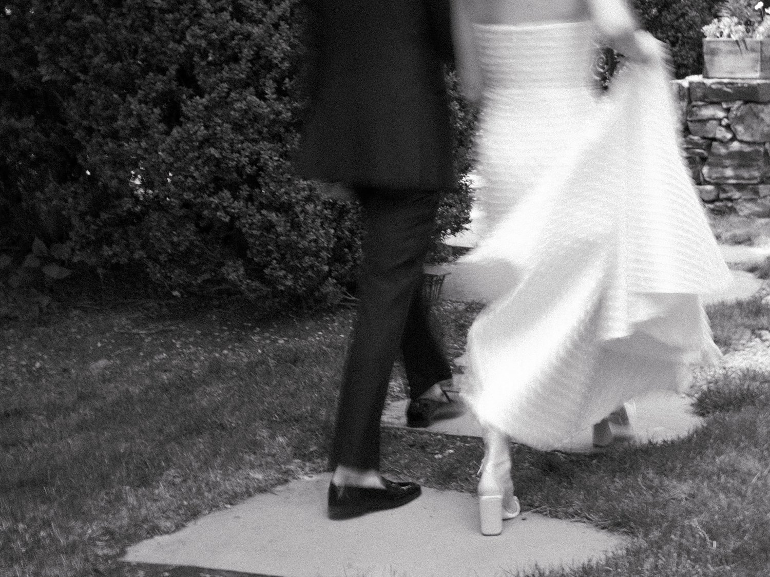 blurred photo of couple walking through gardens at The Country Club of New Canaan