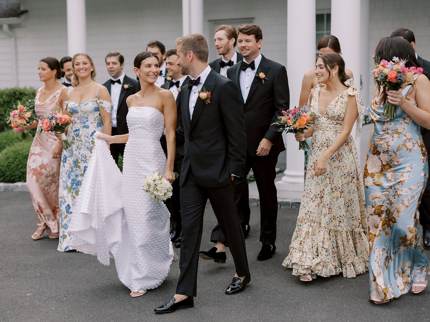 bride and groom hold hands walking with bridesmaids and groomsmen outside The Country Club of New Canaan