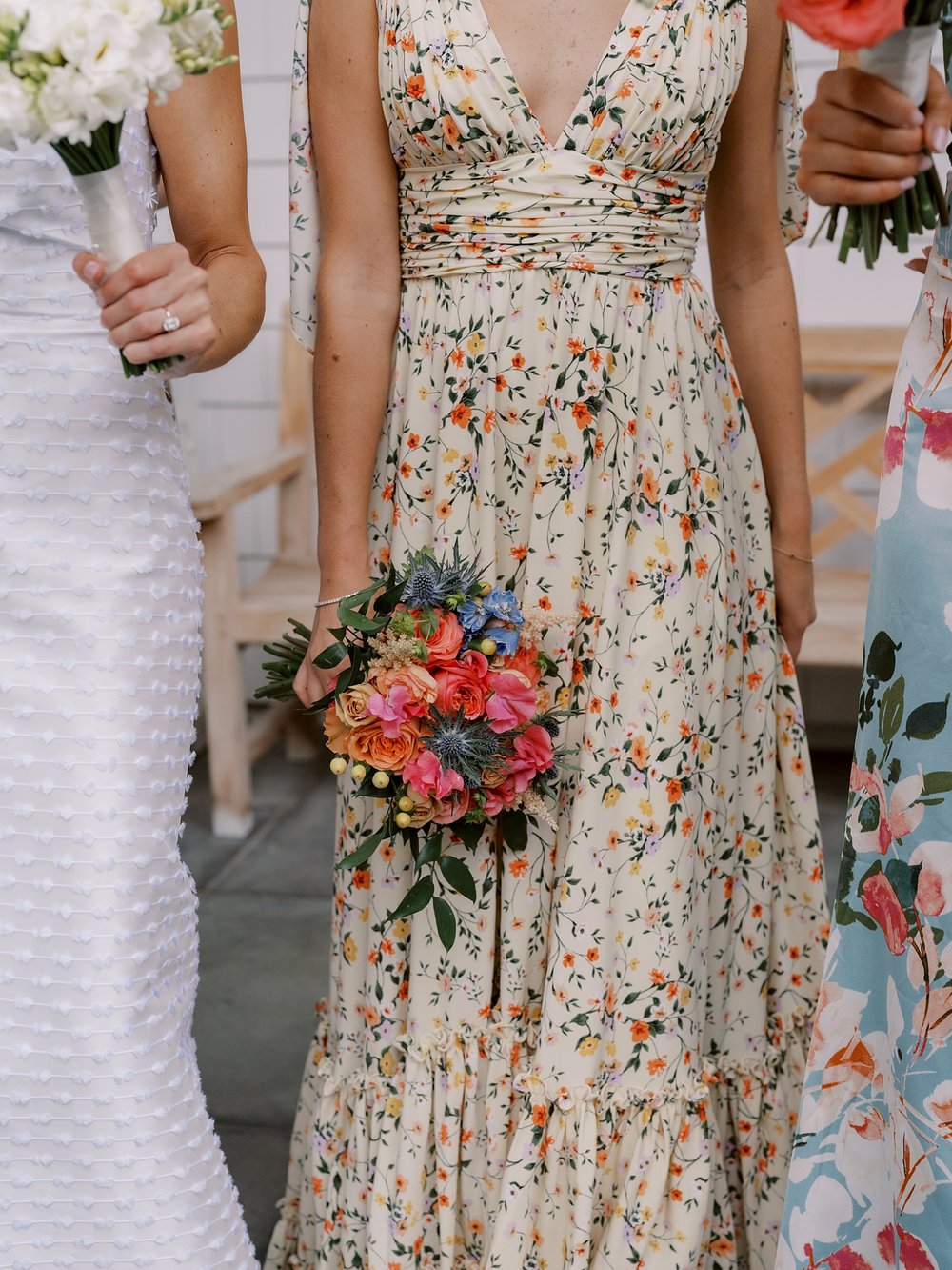 bridesmaid in flower gown holds bouquet of pink and orange flowers 
