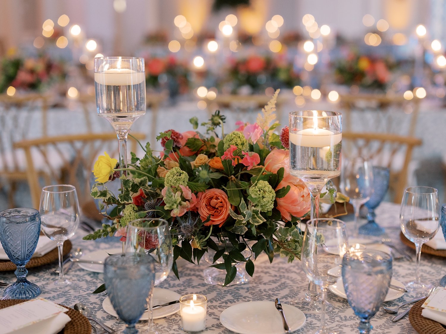 summer wedding reception with bright flowers and candle centerpieces 