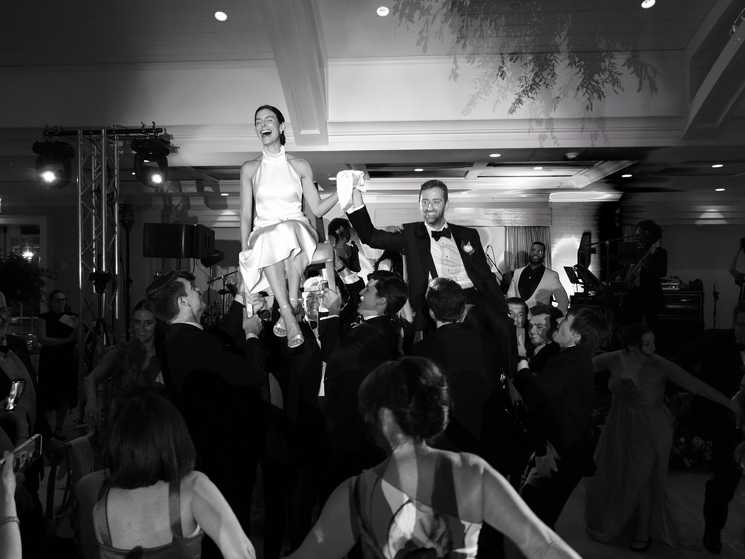 guests lift up bride and groom during wedding reception 