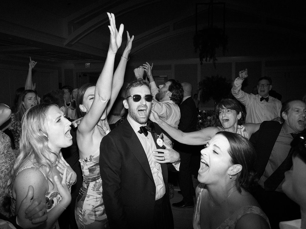 groom stands in middle of dance floor around guests during New Canaan wedding reception