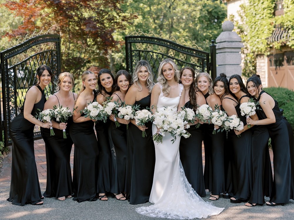 bride poses with 10 bridesmaids in mismatched gowns at the Ashford Estate