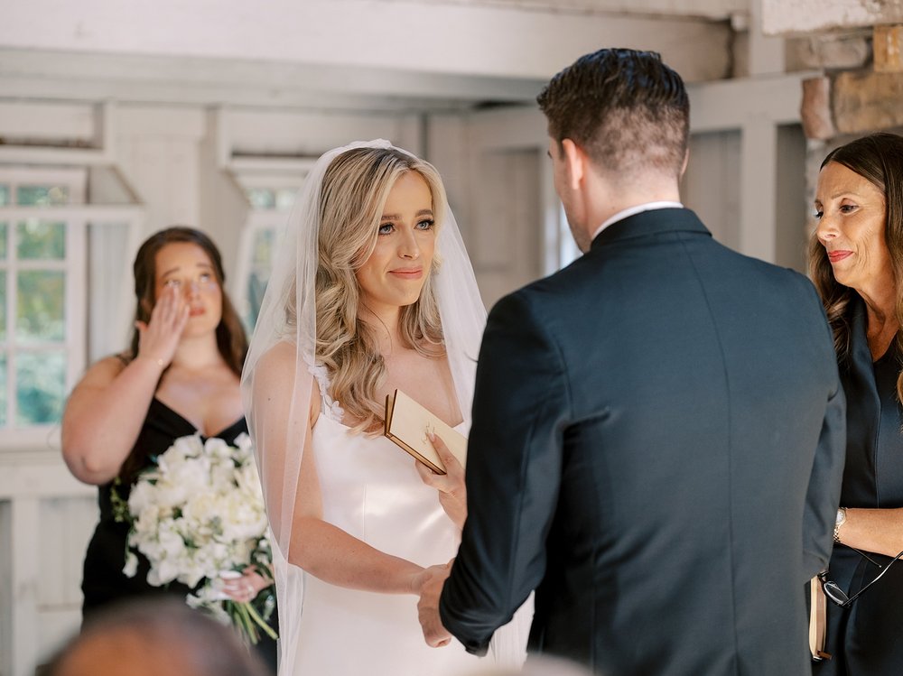 bride and groom hold hands during vows at the Ashford Estate