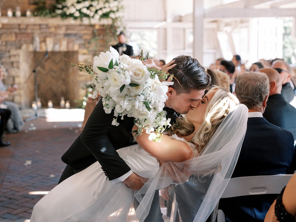bride and groom kiss dipping in aisle after ceremony at the Ashford Estate