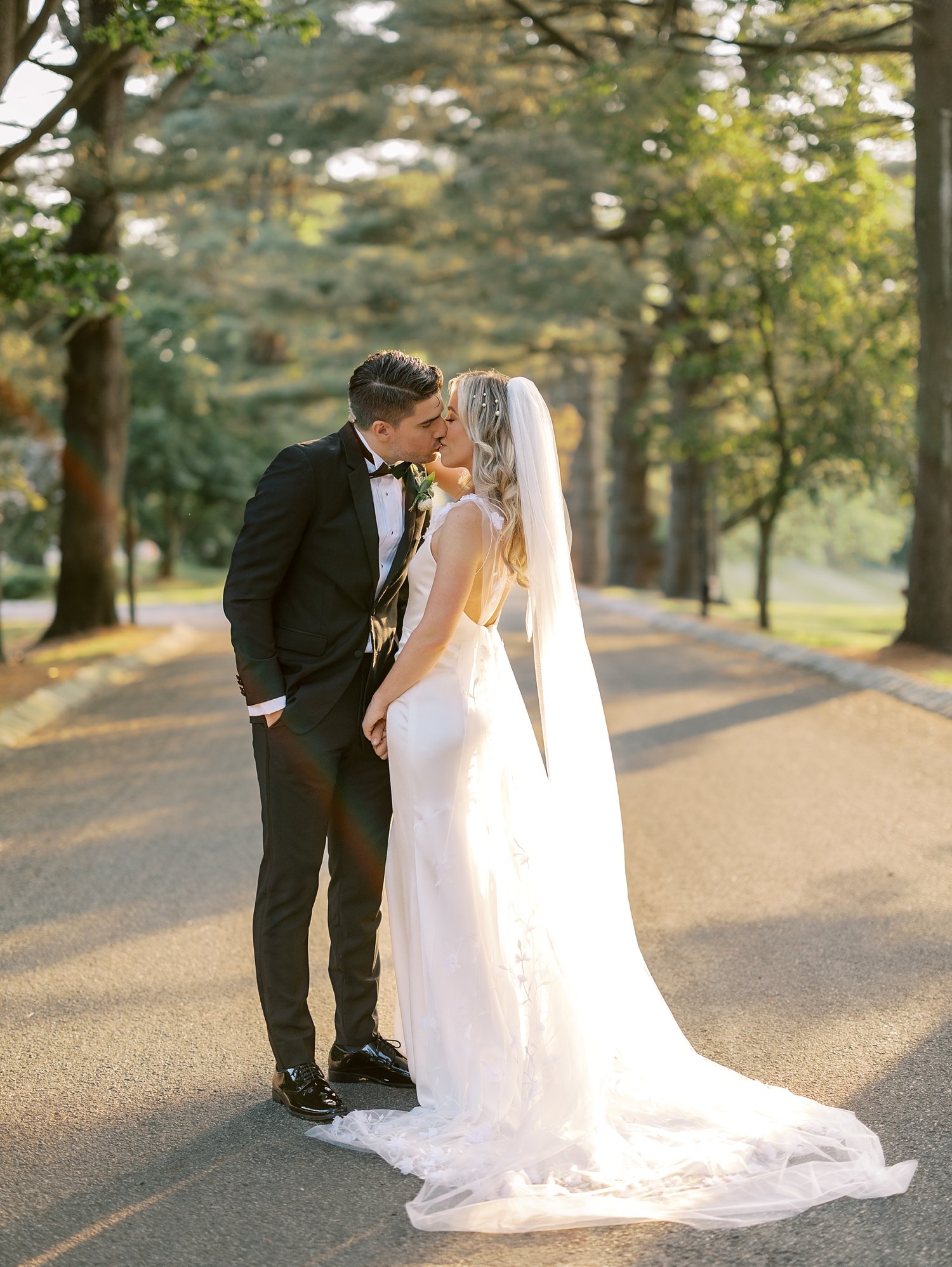 bride and groom kiss on driveway at sunset at the Ashford Estate