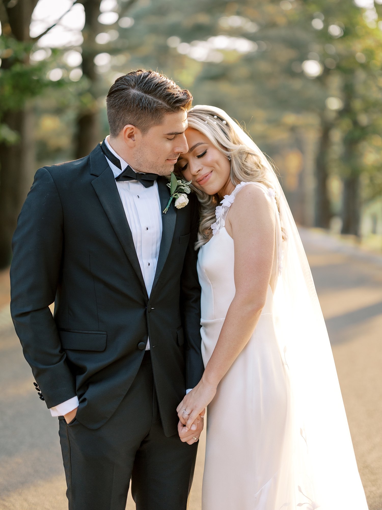 bride leans on groom's shoulder on driveway at the Ashford Estate