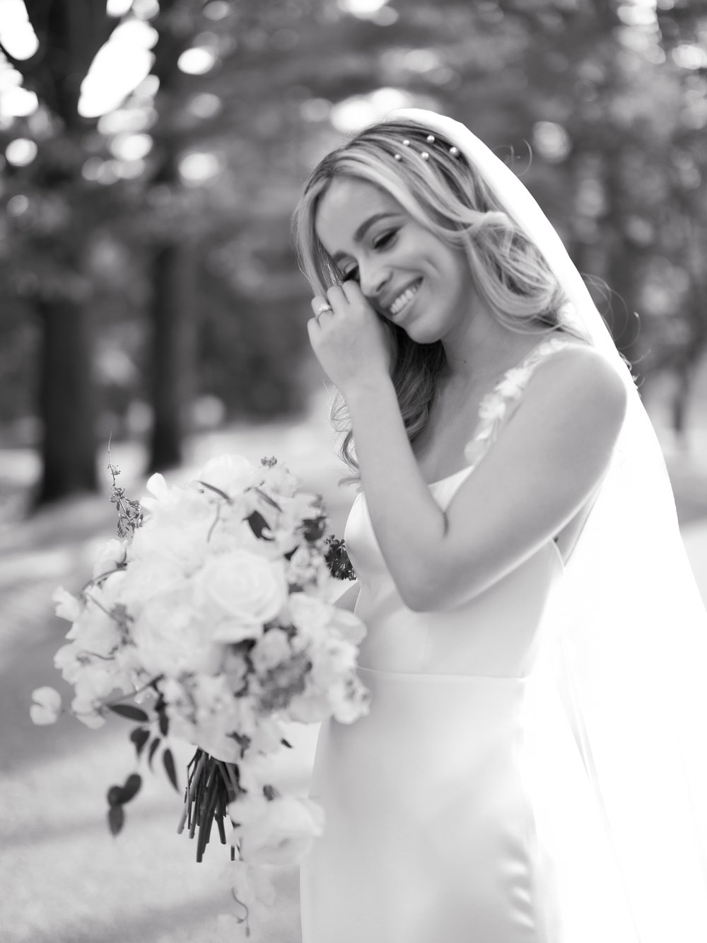 bride wipes tears away from eye during portraits in New Jersey 