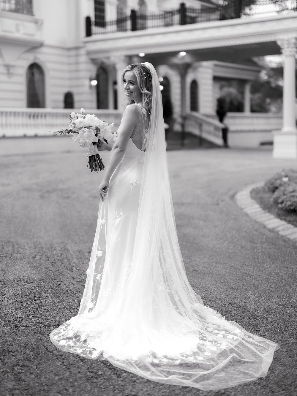 bride holds skirt of wedding gown outside the Ashford Estate