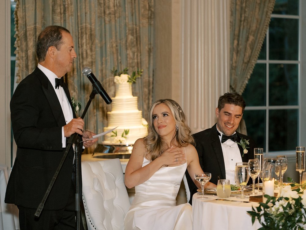 bride and groom listen to speech during NJ wedding reception 