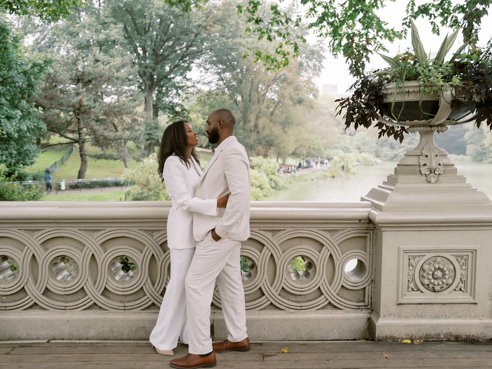 married couple hugs on bridge inside Central Park during anniversary portraits 