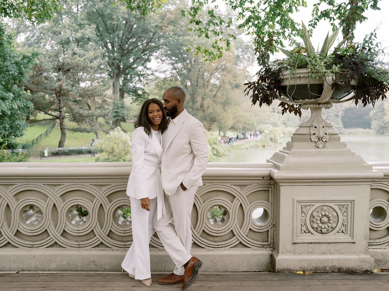 married couple hugs leaning against the bridge inside Central Park