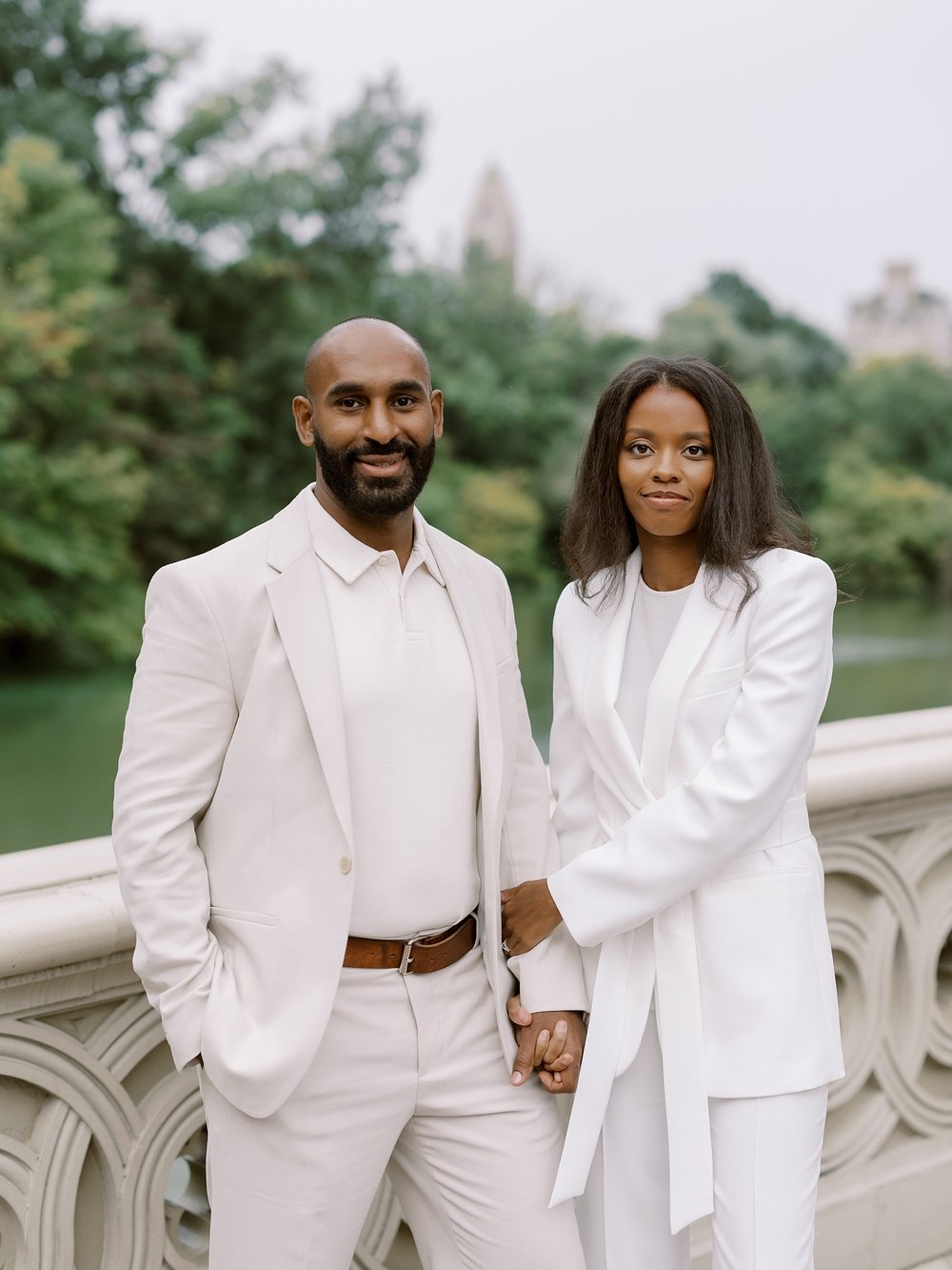 husband and wife pose in white suits during Central Park anniversary portraits 