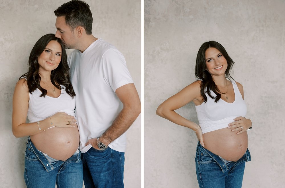 woman holds baby bump in jeans and white bra during maternity portraits in New York City studio