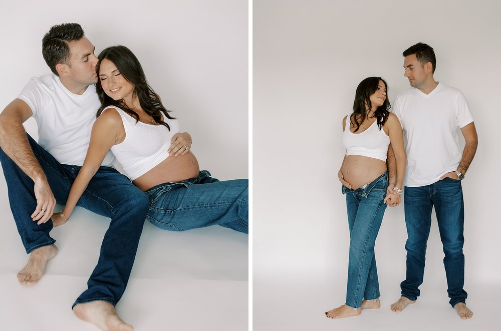 married couple poses in jeans and white shirts during studio maternity session