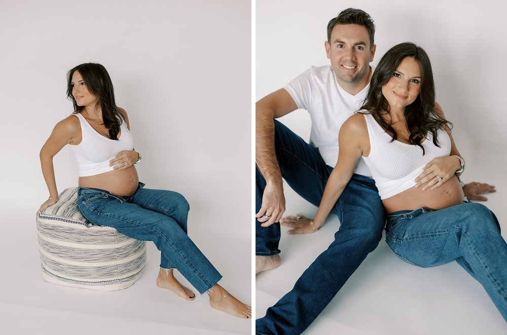woman sits on ottoman holding baby bump during studio maternity session