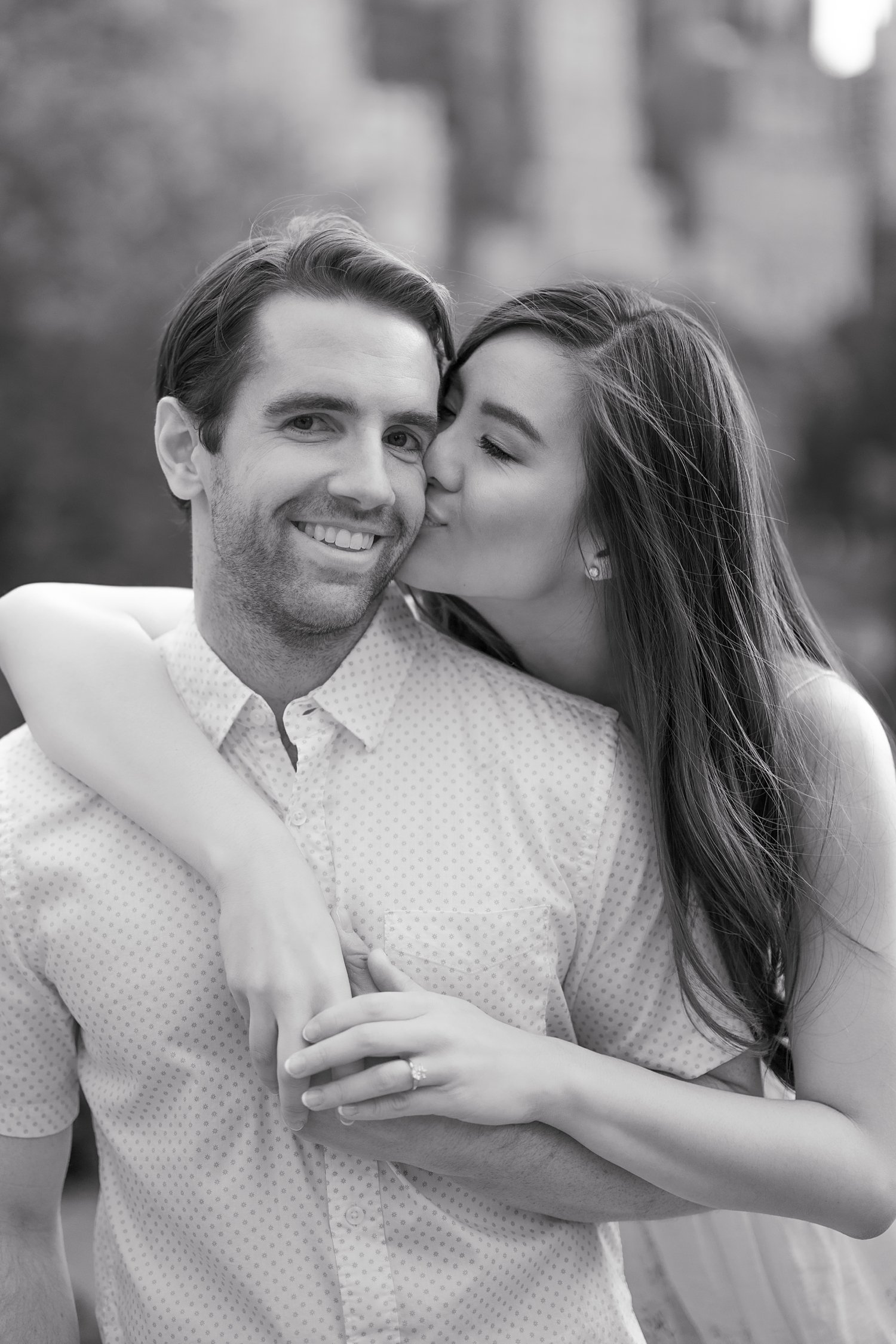 woman hugs man from behind around his shoulders in Central Park