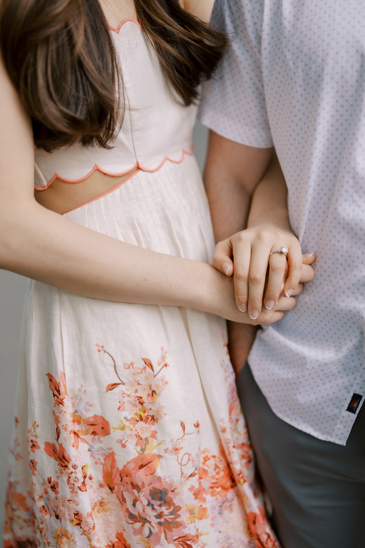 woman loops arm through man's during spring engagement portraits in Central Park