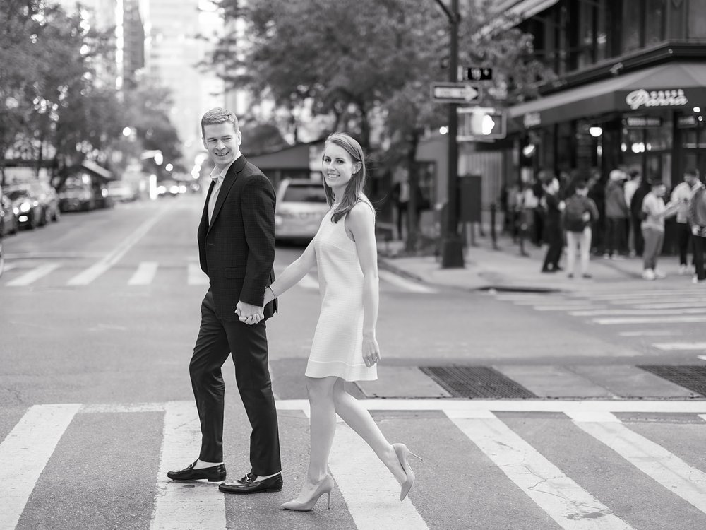 woman and man hold hands crossing street in New York City 