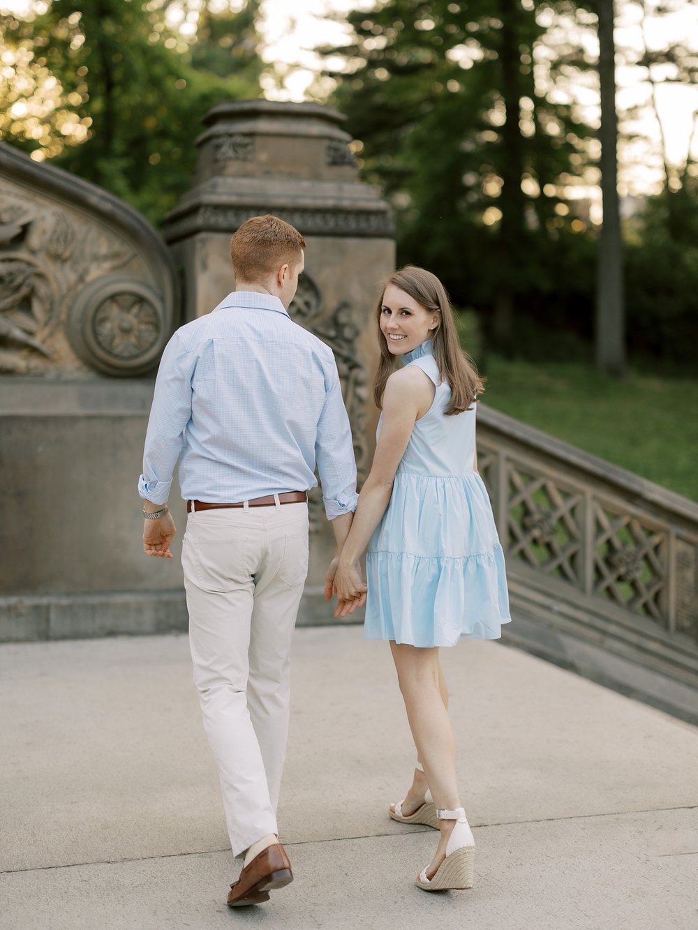 couple holds hands walking up staircase near Bethesda Terrace 